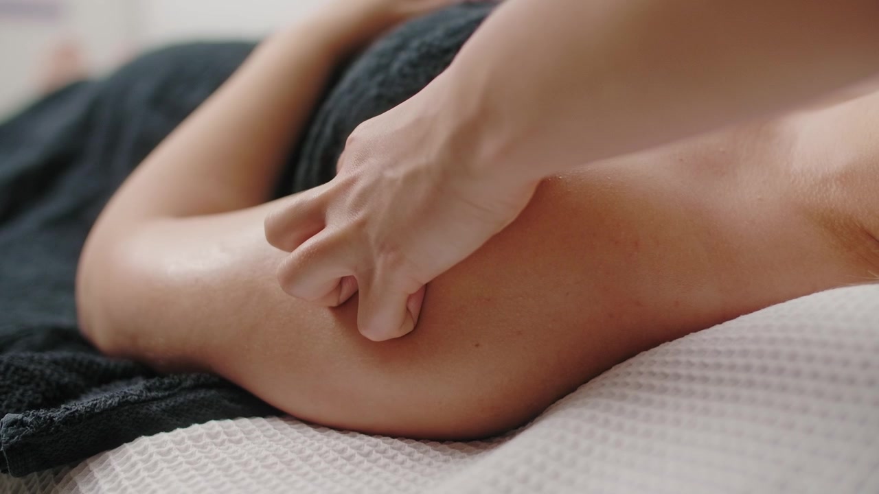 Massaggiatore professionista che massaggia la spalla di un cliente in una spa