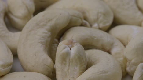 cerca de la muñeca izquierda tiro de una porción de nueces de caju crudas, uno podrido en la pila