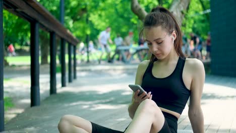 sportswoman resting and using smartphone after workout