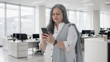 una mujer de negocios india feliz hablando por teléfono.
