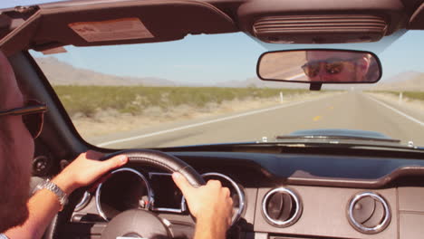 man in convertible car driving along open road shot on r3d