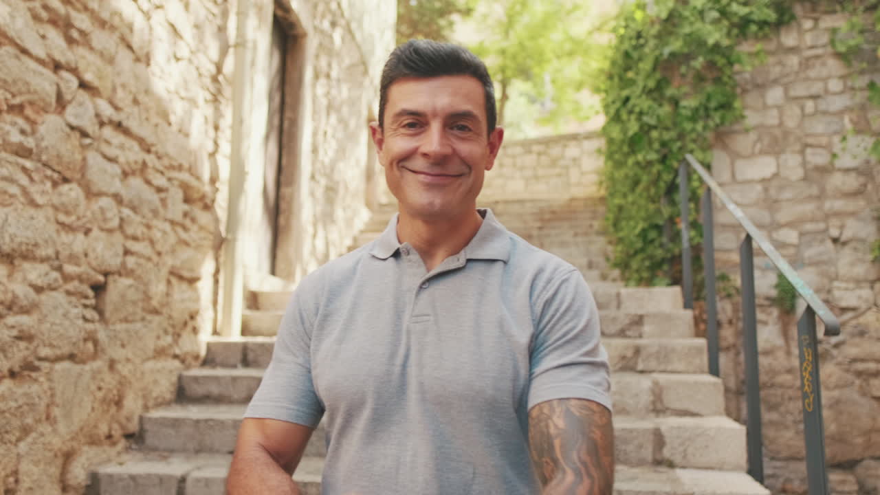 Confident Man Smiling at Camera in Old Stone Alley