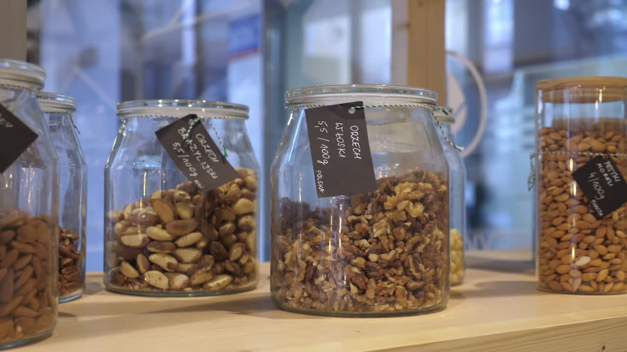 Zero waste sustainable lifestyle. Glass jars with organic nuts in green eco package shop