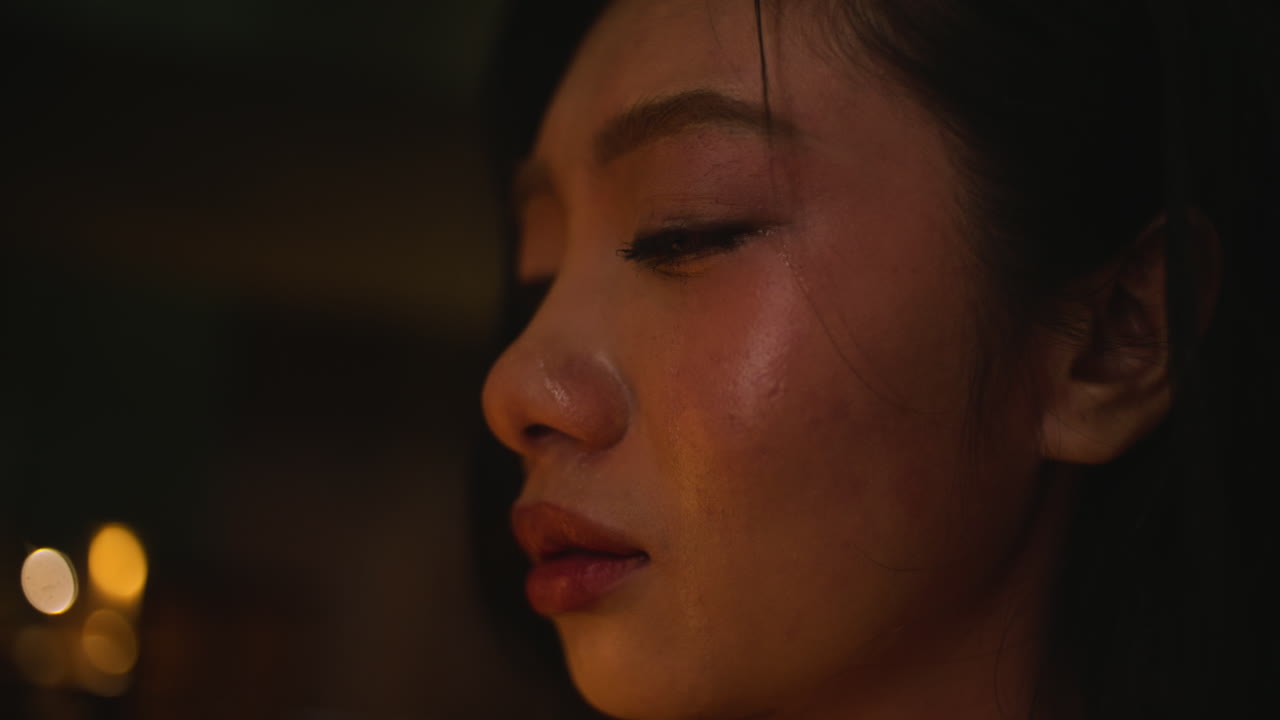 Sad Asian woman with tears in close-up, reflecting on emotional moment
