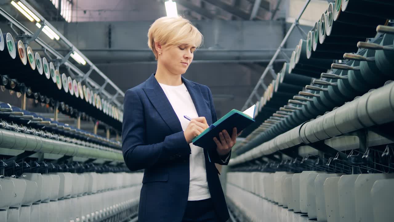 женщина в деловом костюме контролирует швейное оборудование