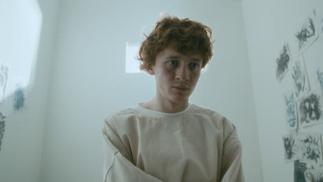 depressed psychiatric patient staring ahead with sad expression in asylum