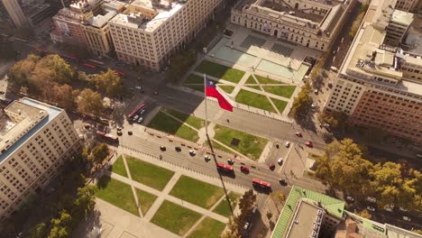 patriotic flag of chile in center of de chile at sunset time. aerial top down shot. trees at famous avenue with cars.traffic scene with tram and cars.