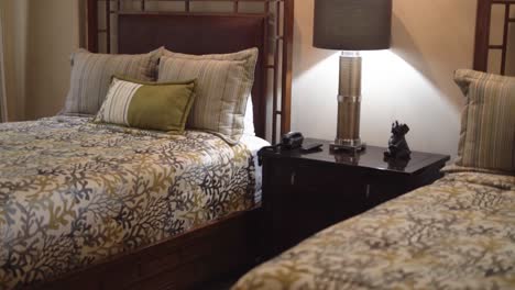 room with two beds next to bedside table and lighted lamp