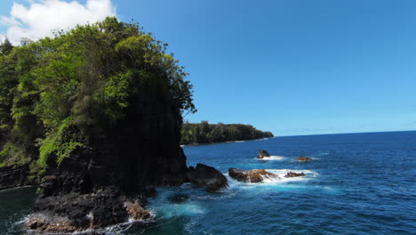 Slow-motion-FPV-drone-shot-over-blue-ocean-water-towards-rocky-coastline