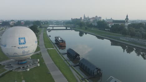 Toma-Aérea-De-Drones-Del-Casco-Antiguo-Del-Castillo-De-Wawel-En-Cracovia,-Polonia,-Con-El-Río-Vístula-Al-Amanecer.