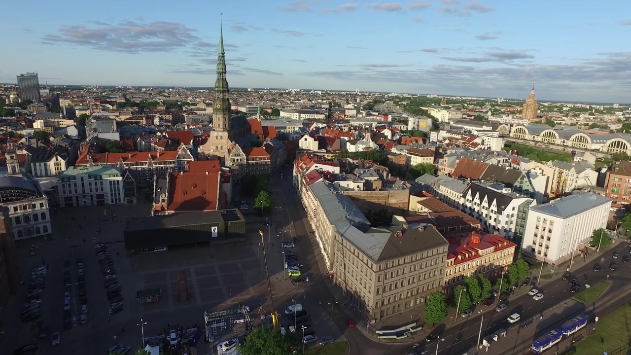 Veduta aerea della Vecchia Riga, Lettonia, con la Chiesa di San Pietro durante un soleggiato pomeriggio estivo con cieli azzurri e sereni e vivaci tetti rossi, catturata da una prospettiva ad alta angolazione che mostra la vita urbana.