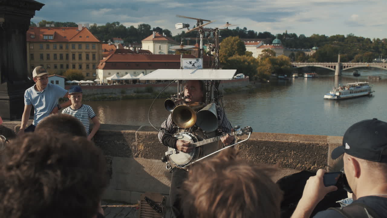 Tourists entertained by multi instrument musician at Charles Bridge, PRAGUE, CZECH REPUBLIC