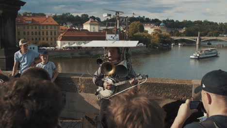 tourists entertained by multi instrument musician at charles bridge, prague, czech republic
