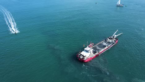 unique view of a industrial sand dredging vessel disrupting a sensitive marine habitat as it maneuvers