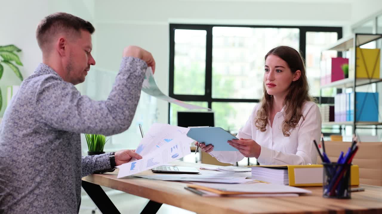Funcionários e funcionárias trabalham com documentos com gráficos.