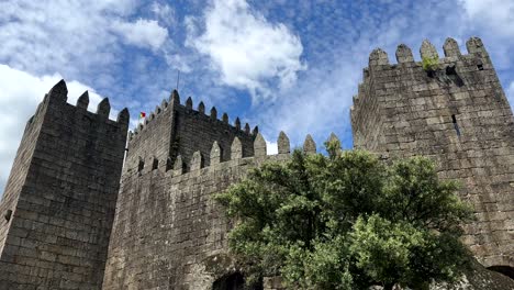 Aufnahme-Der-Historischen-Burg-Von-Guimaraes-An-Einem-Sonnigen-Tag-In-Portugal-Von-Unten-Nach-Oben,-Nach-Oben-Geneigt