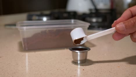 Close-up-shot-loading-Reusable-Coffee-capsule-with-coffee-powder-in-Slow-motion