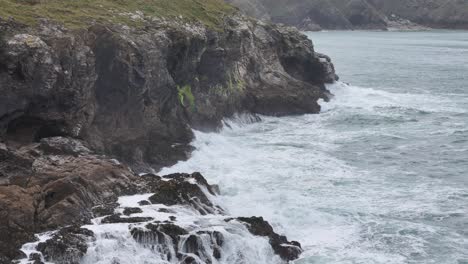 Stürmische-Dramatische-Wellen-In-Zeitlupe-Explodieren-An-Der-Küste-Cornwalls-In-Der-Nähe-Von-Port-Isaac,-Großbritannien,-Drohne,-Luftaufnahme