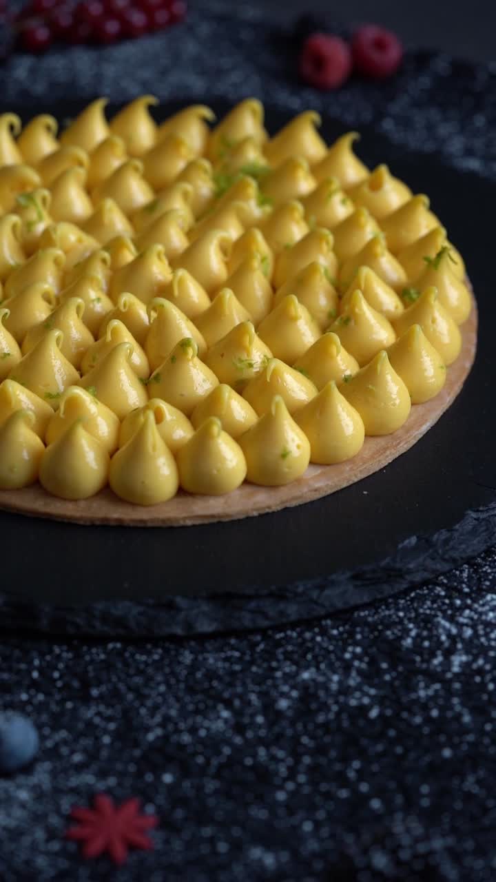 Scatto ravvicinato di una crostata dorata guarnita con crema al limone liscia.
