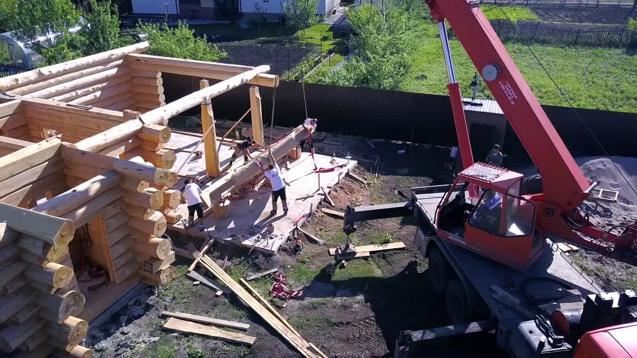 construcción de cabañas de madera con grúa y trabajadores