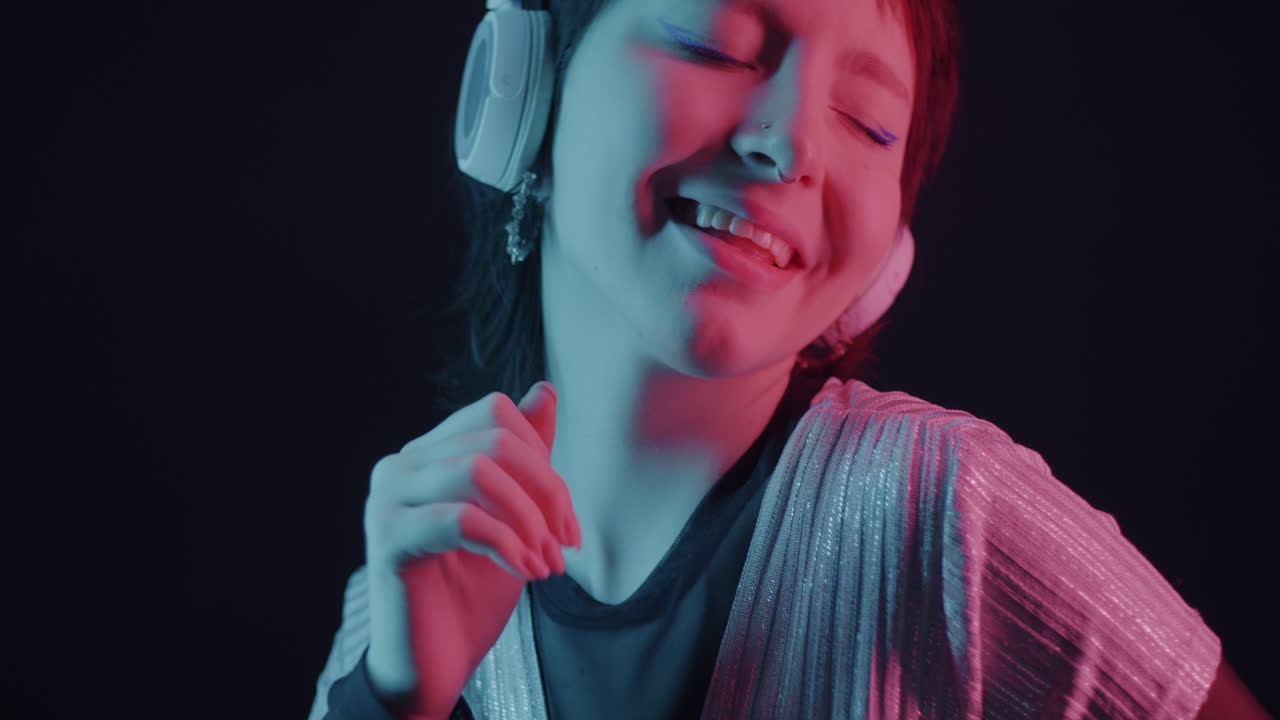 Teenage Girl Dancing with Headphones in Neon Light