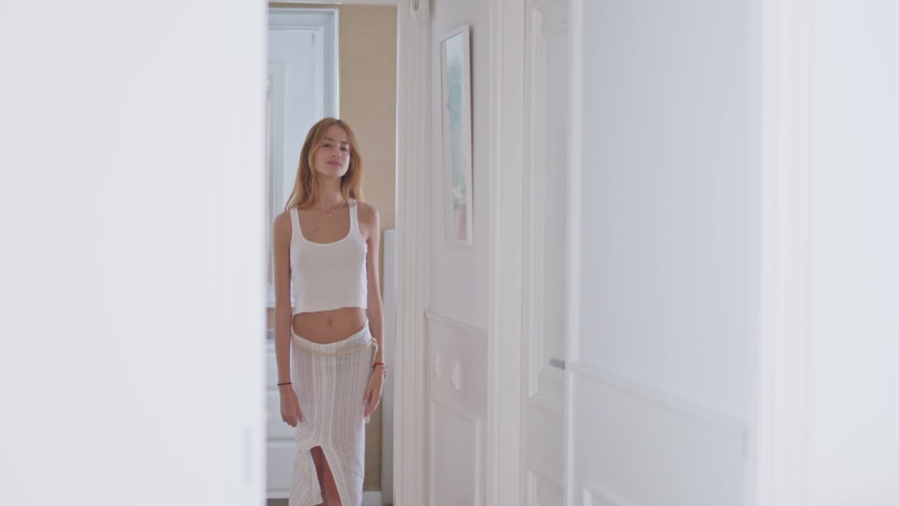 방의 거울 근처의 벽에 기대어 있는 감각적인 젊은 여성