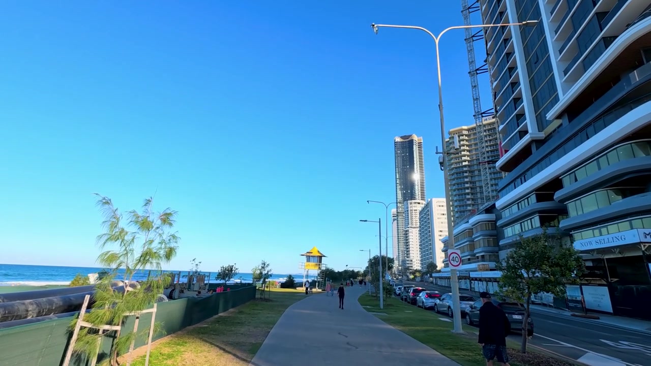 Carrellata grandangolare lungo la passerella costiera oltre i grattacieli a Surfers Paradise, Australia.