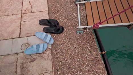 pair of blue and black sandals on a dock by the water
