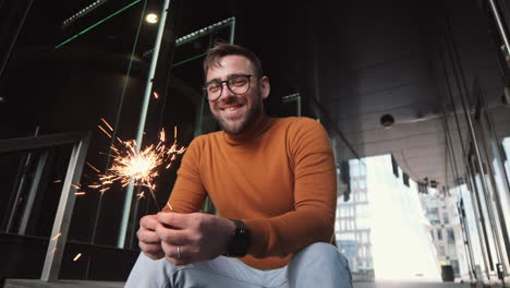 man holding sparkler smiling