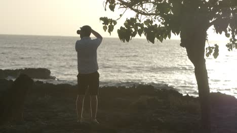 man taking photos of sunset at the beach
