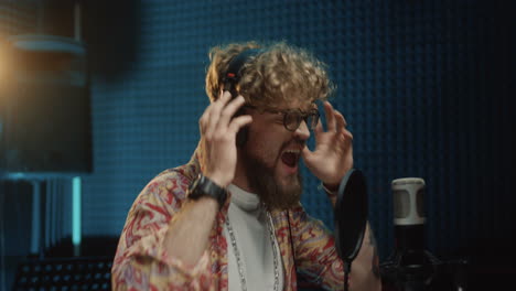 Close-Up-Of-The-Emotional-Passionate-Young-Stylish-Guy-Singing-In-The-Studio-Mic-And-Recording-A-Song