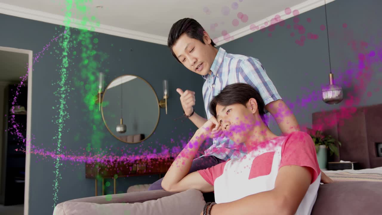 Father giving health support to son on sofa, ribbon appearing, sweeping across room overlaying them