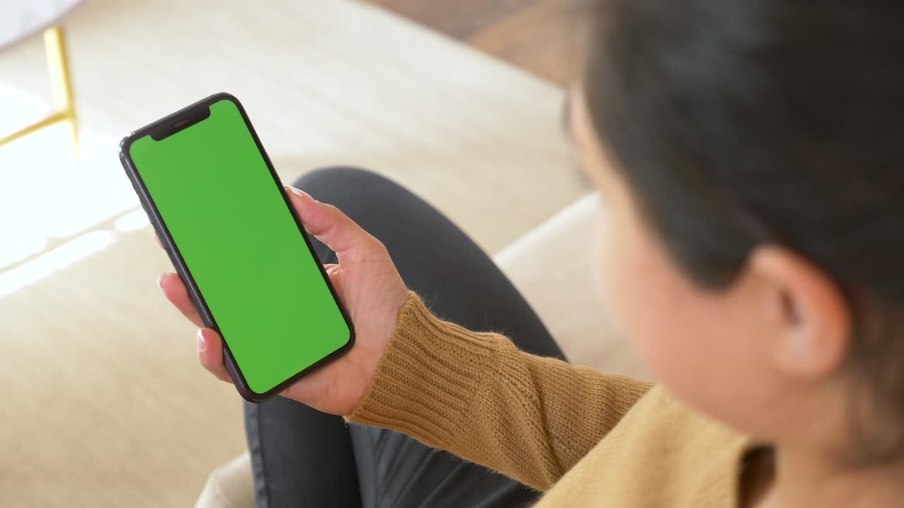 스마트폰에서 인도 여성 손, 작은 손 움직임으로 정적 영상. 움직임을 추적하기 위해 화면에 표시. 인도 젊은 여성이 밝은 쾌적한 방에서 온라인 비디오 통화에서 이야기