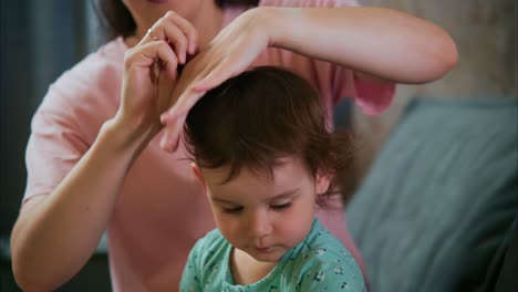 a caregiver gently styles a child's hair with a comb and hair tie, capturing a heartwarming moment of tenderness and bonding in a cozy setting
