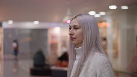 side view fashionista walking toward boutique window, placing hands on glass display in admiration, soft lighting reflecting boutique interior, blurred background models and lights creating elegant