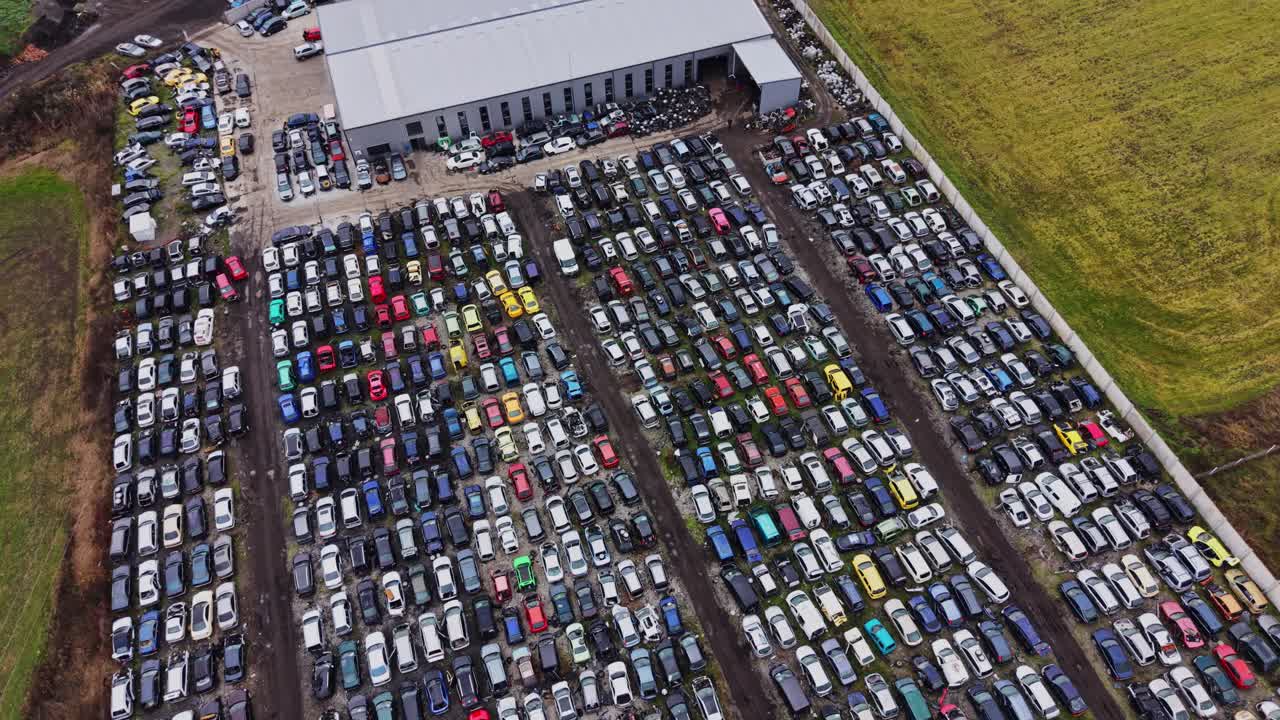 Stor bilparkering med mange parkerede køretøjer i et landligt område