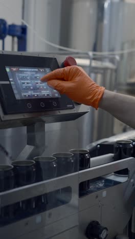 worker adjusting settings on a beverage canning machine