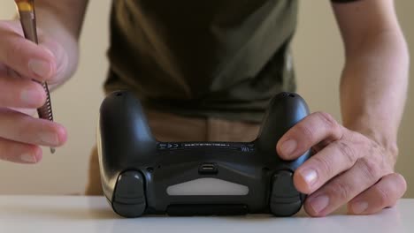hombre arreglando el controlador de juego, de cerca