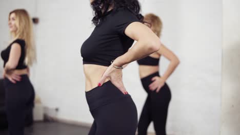 a group of female dancers learning bachata main elements. twisting body and shaking head. groovy moves of latin dance.