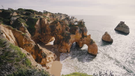 overview of the beach from the top of the cliffs in the algarve portugal on a sunny day