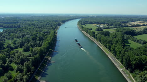 aerial view of a barge on a canal through lush green landscapes