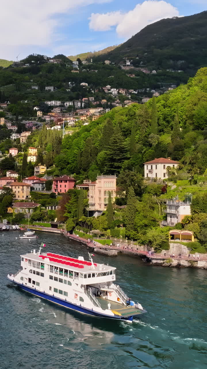 Aerial drone view hip navigating on Lake Como, Italy on a sunny day. Vertical