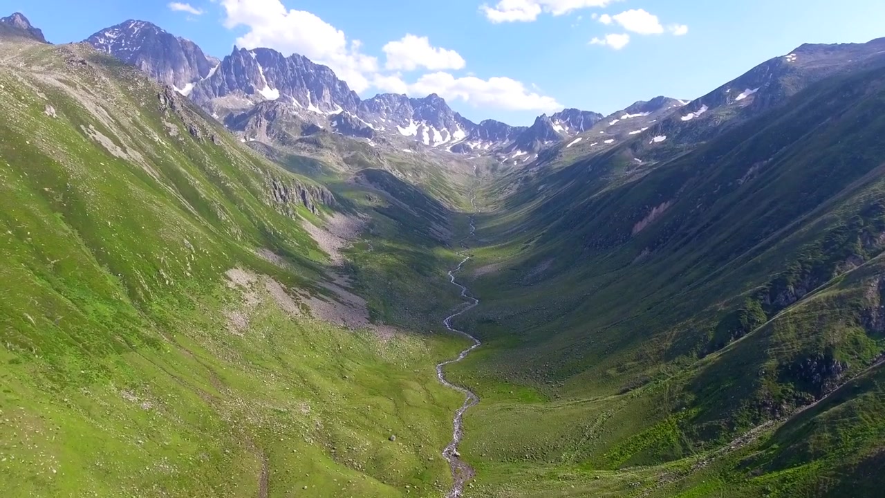 Veduta aerea di un ruscello sinuoso in una lussureggiante valle di montagna