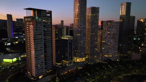 Flying-over-the-La-Mexicana-Park-and-in-middle-of-skyscrapers-in-Santa-Fe,-Mexico---Aerial-view