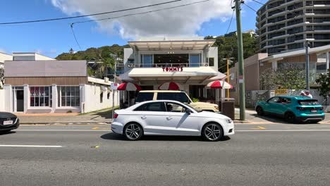 cars passing by a restaurant on currumbin beach