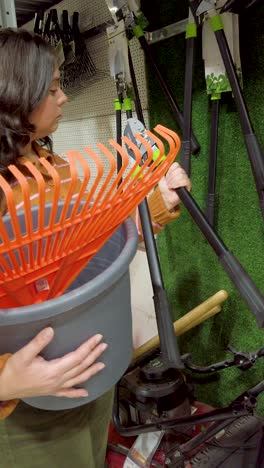 woman choosing gardening tools in hardware store