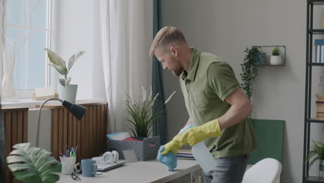 man cleaning his home office desk