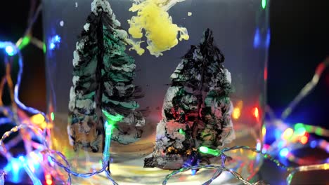 colored paint floating in water tank surrounded by christmas lights. stable shot with the sony a7iii