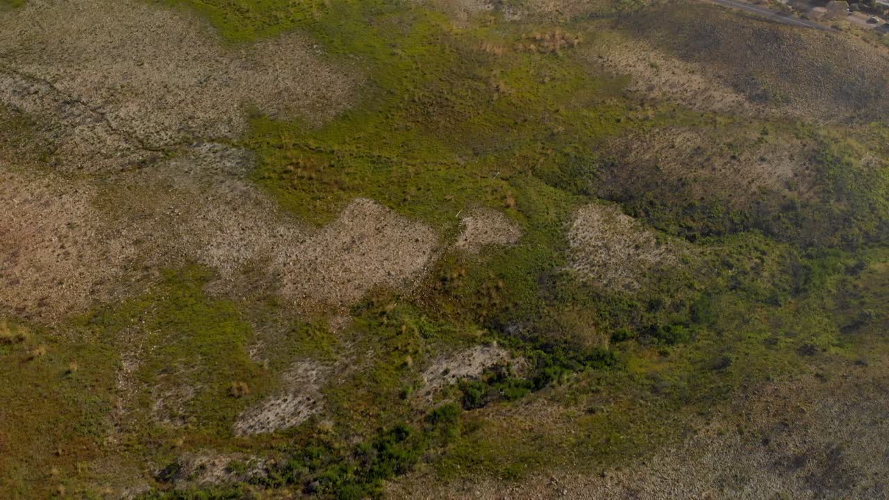 Drone panning down from mountain range, road and sea to foot of mountain