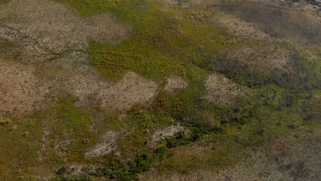 drone panning down from mountain range, road and sea to foot of mountain